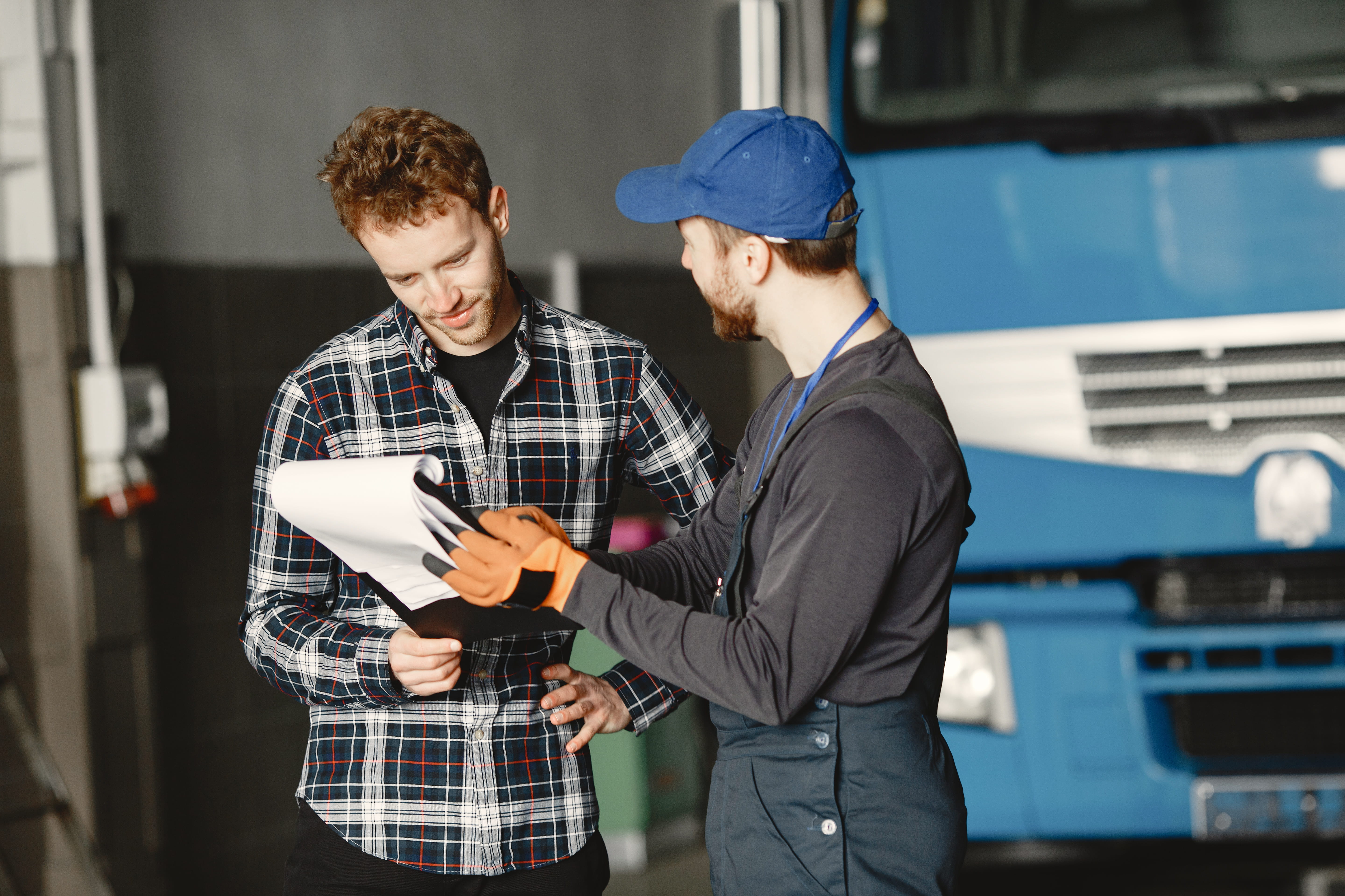 two-guys-talking-about-work-work-garage-near-truck-transfer-documents-with-goods-1.jpg